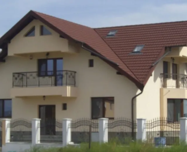 Casă rezidențială cu acoperiș din țiglă metalică și ferestre de mansardă